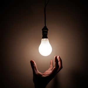 Person Holding White Light Bulb